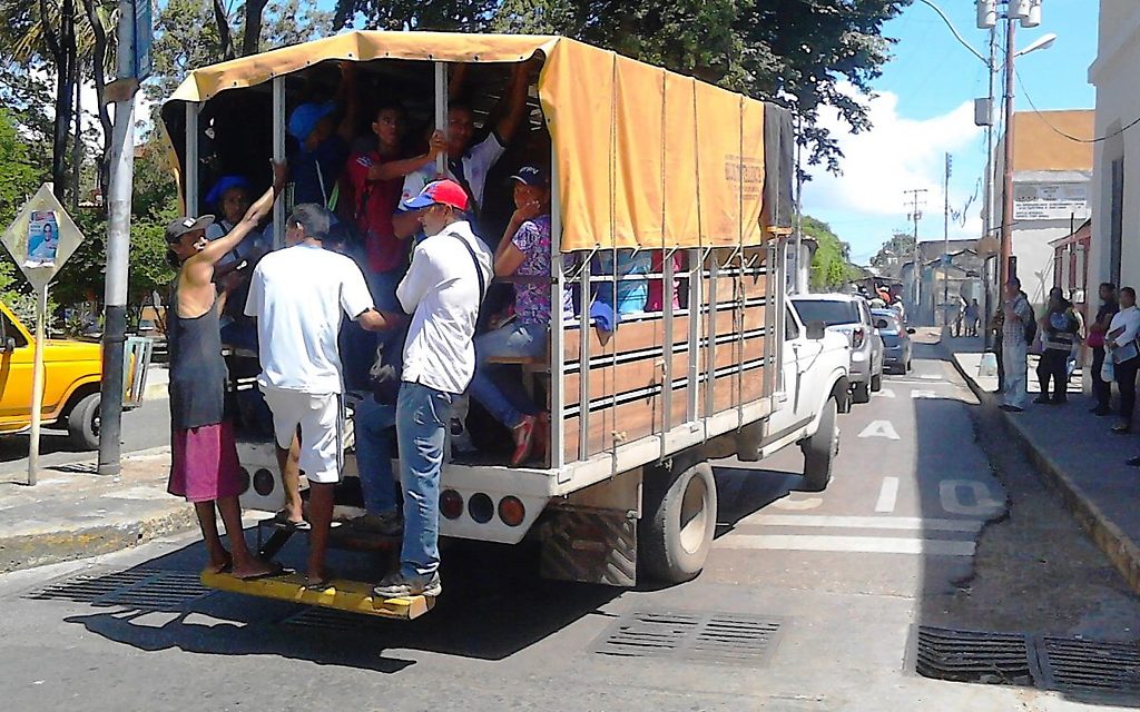 Pasajeros en un camión de carga "perrera" utilizado como transporte público en Valencia, Venezuela, el 11 de julio de 2018