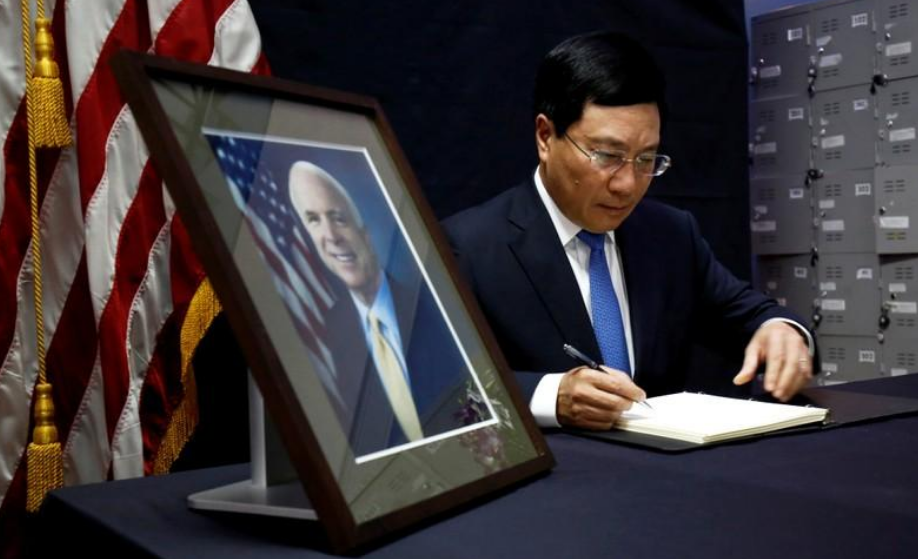 El viceprimer ministro y ministro de Relaciones Exteriores de Vietnam, Pham Binh Minh, escribe en un libro de condolencias cerca de un retrato del senador estadounidense John McCain, en la embajada de Estados Unidos en Hanoi, Vietnam