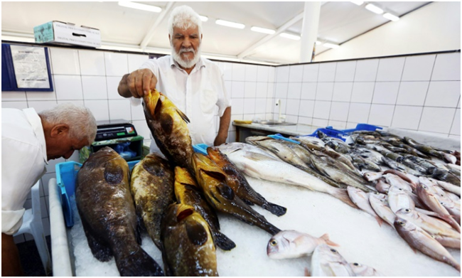 Pescaderos libios exponen el producto del día en el mercado de pescado de Trípoli, el 4 de agosto de 2018