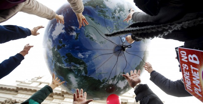 Manifestantes tiran un globo enorme con forma de mundo en la protesta de Roma, Italia, por el cambio climático. 