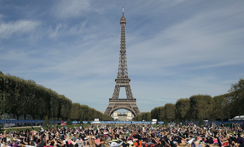 Personas practicando yoga durante evento deportivo en la Torre Eiffel, París