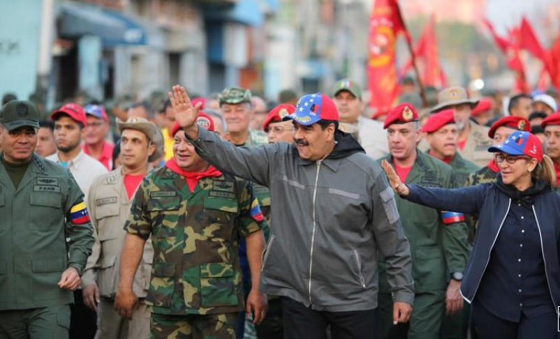 El presidente de Venezuela, Nicolás Maduro, y su esposa, Cilia Flores, saludan junto a soldados en una ceremonia en Maracay, Venezuela