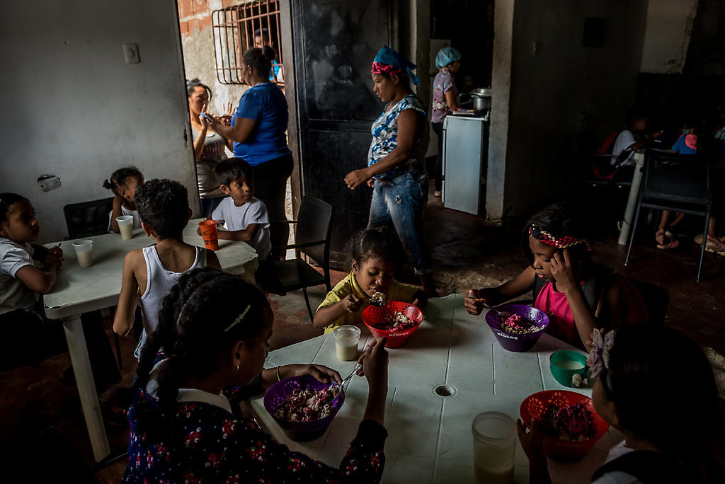 Niños comiendo el almuerzo la semana pasada en una cocina comunitaria en Caracas patrocinada por políticos de la oposición.