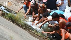 Habitantes de la ciudad recogen agua de una salida de manantial