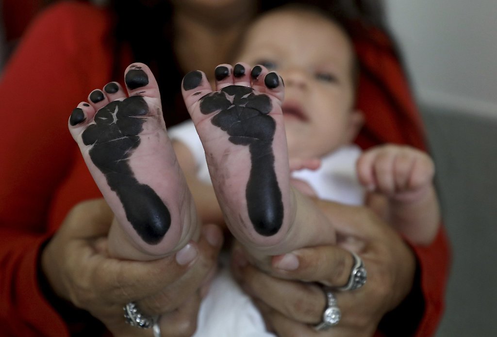 A niña de migrantes venezolanos nacida en Colombia le toman las huellas para el certificado de nacimiento, lo que no significa que tenga la nacionalidad colombiana