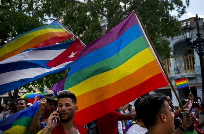 Activistas LGBTQ agitan las banderas arcoíris y cubana en La Habana, Cuba.