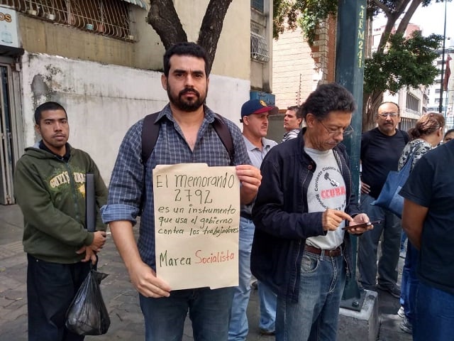 Gustavo Martínez, de Marea Socialista y de Trabajadores en Lucha, muestra   un cartel que denuncia al Memorando 2792 como un instrumento del gobierno contra los trabajadores