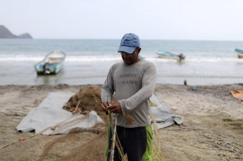 Un pescador repara una red de pescar en Patanemo, Venezuela. 17 de mayo de 2019