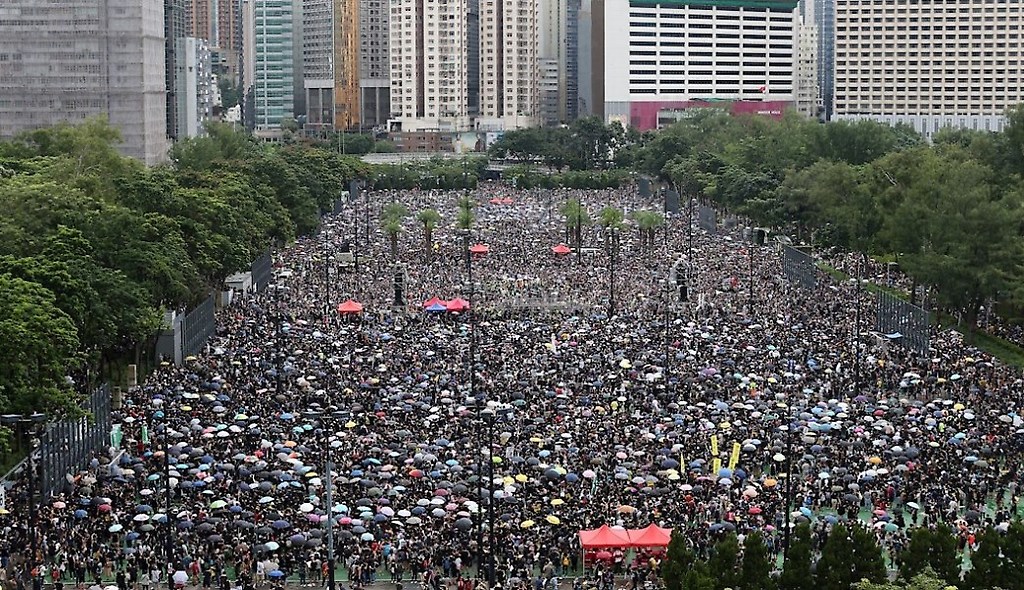Una multitud se refugia de la lluvia bajo paraguas durante una nueva marcha contra el gobierno en Hong Kong.