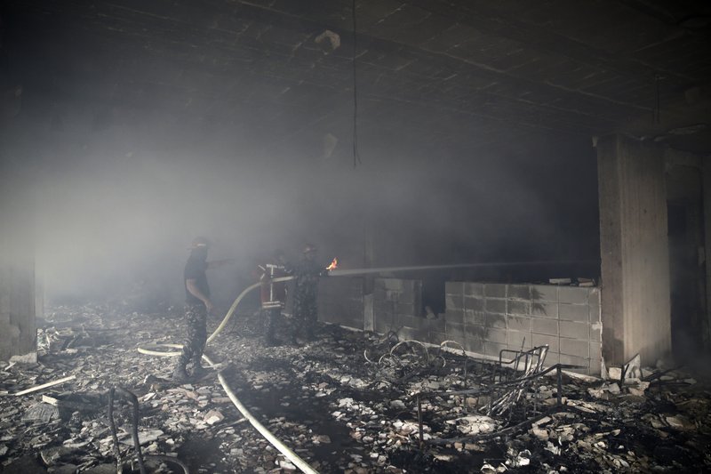 Bomberos libaneses extinguen llamas dentro de un edificio azotado por un incendio
