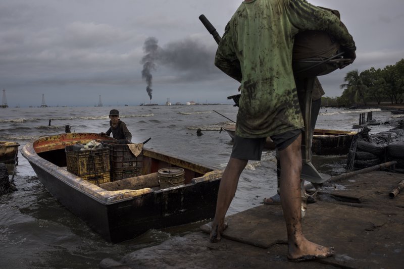 Pescadores en el Lago Maracaibo, en Venezuela, sucios por la contaminación petrolera que afecta la zona