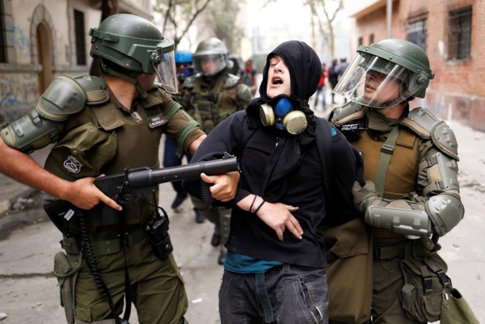 Un manifestante es detenido por fuerzas de seguridad durante la ola de protestas sociales contra el gobierno chileno en Santiago, Chile