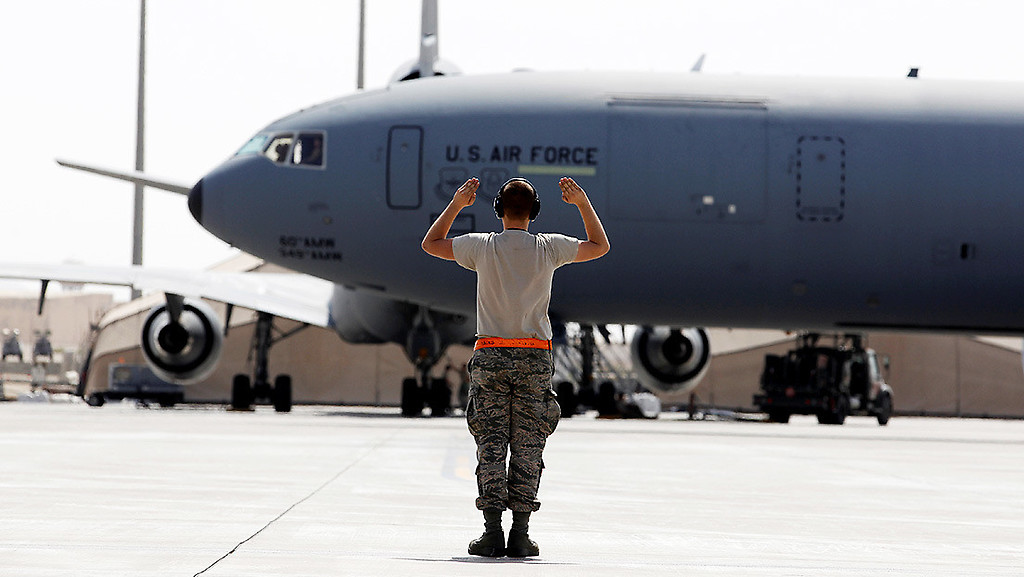 Un militar estadounidense hace señales al piloto de un avión cisterna KC-10 Extender en una base aérea en el golfo Pérsico, el 13 de marzo de 2017.