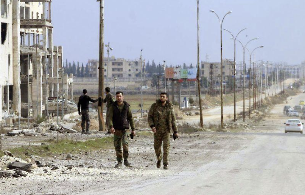 Soldados del ejército sirio caminan por una calle en la provincia de Alepo