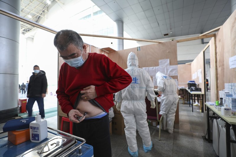 Paciente inyectándose insulina en un hospital temporal para enfermos de COVID-19 en el Gimnasio Tazihu en Wuhan, China