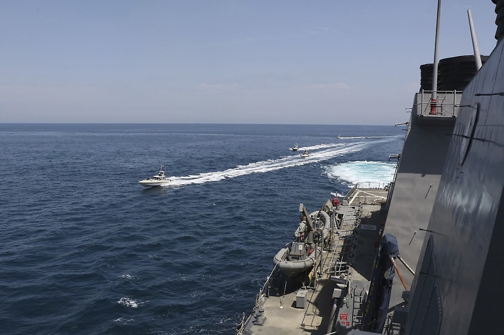Foto de la Marina de EEUU muestra varias lanchas rápidas iraníes alrededor un buque de guerra estadounidense.