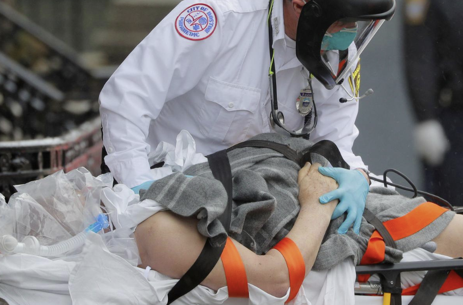 Personal médico de emergencia realiza maniobras de resucitación en un paciente camino a la ambulancia en Boston, EEUU