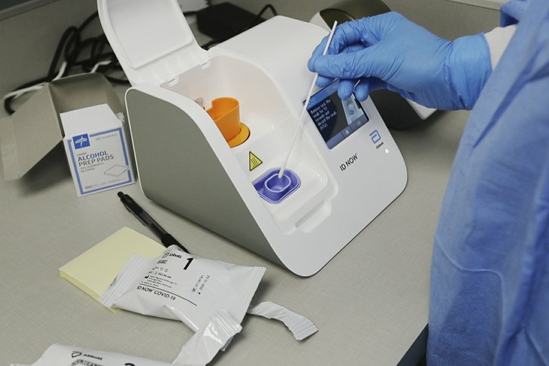 Imagen de un trabajador metiendo una muestra en una máquina de Abbott Laboratories en Detroit, el 10/4/2020
