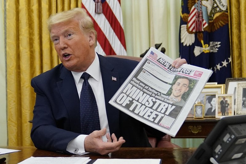 El presidente Donald Trump sostiene una edición del New York Post antes de firmar un decreto que afecta a Twitter y otras redes sociales