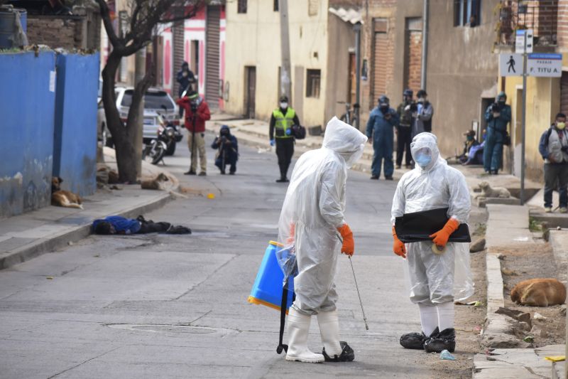 Personal de sanidad llega a un barrio de Bolivia a recoger un cadáver sacado a la calle presumiblemente víctima de coronavirus