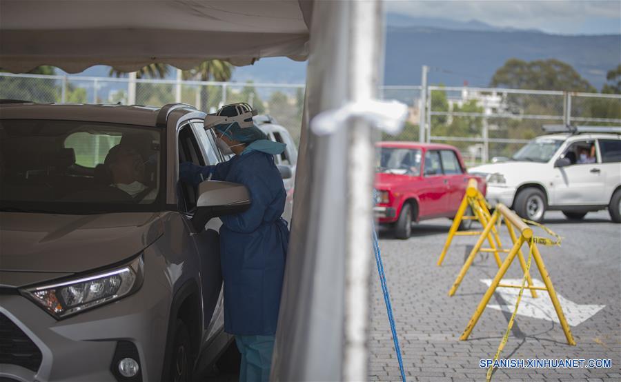 Una médica portando careta y mascarilla realiza una prueba de la enfermedad causada por el nuevo coronavirus (COVID-19) a hombre en un autoservicio, en Quito, capital de Ecuador