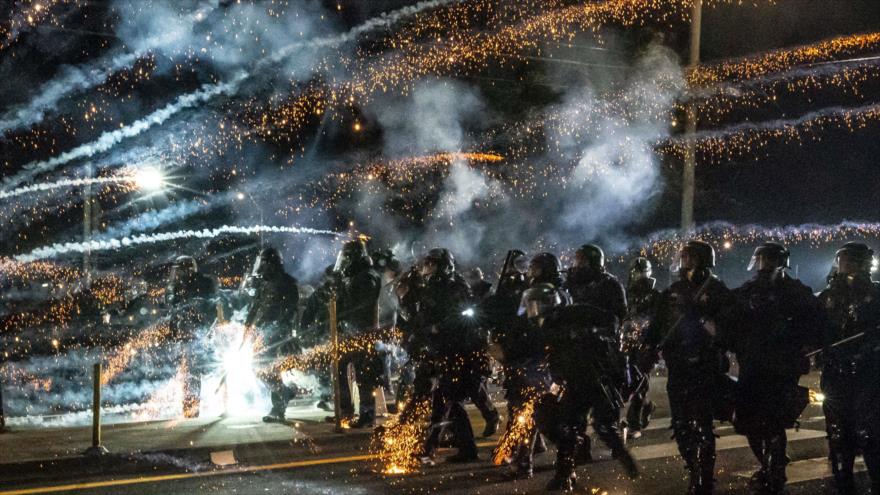 Los agentes del estado de Oregón, EE.UU., avanzan a través de gas lacrimógeno mientras dispersan una protesta antirracista