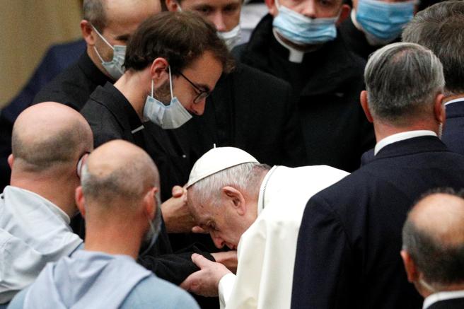 El papa Francisco sin mascarilla besa las manos de un sacerdote