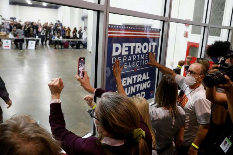 Manifestantes se aprietan contra las paredes de vidrio de un centro donde se contabilizan votos en Detroit, Michigan, para pedir que se dejen de contar los sufragios.
