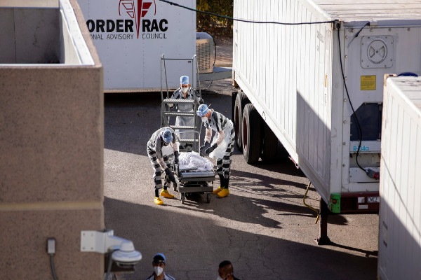 Presos trasladan cuerpos a los remolques refrigerados, desplegados durante una oleada de muertes por covid-19 en El Paso, Texas, EEUU.