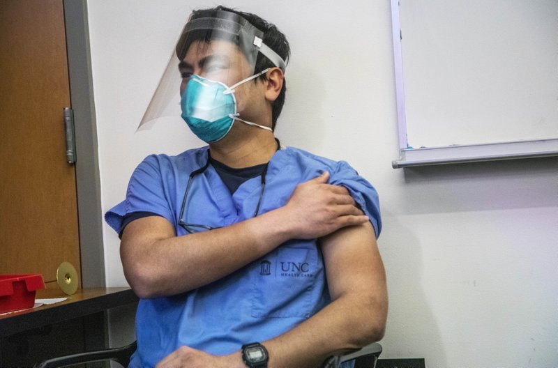 Un doctor se aprieta el brazo tras recibir una dosis de la vacuna contra el Covid-19
