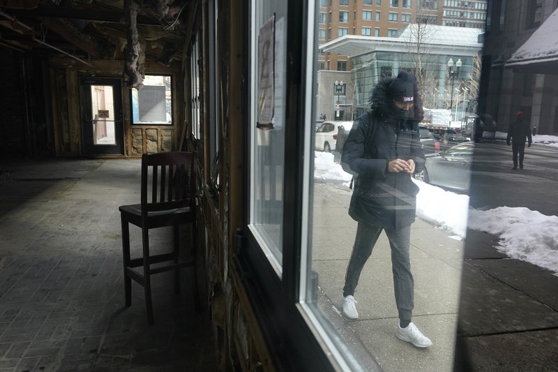 Peatón pasa junto a un edificio vacío que solía ser un restaurante, en Boston