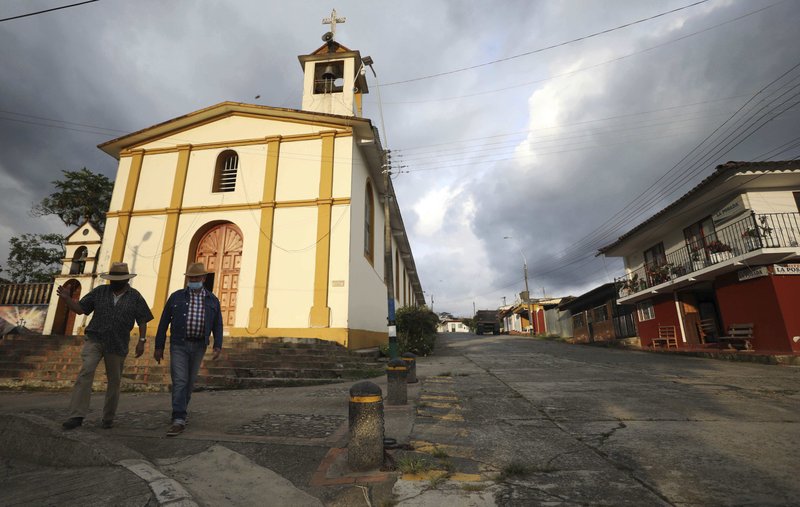 Hombres con mascarilla para frenar la propagación del Covid-19, caminan en Campohermoso, Colombia