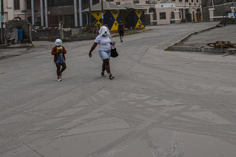 Una mujer y una niña caminan por una calle cubierta de ceniza provocada por la erupción del volcán La Soufrière, en Kingstown, San Vicente y Las Granadinas