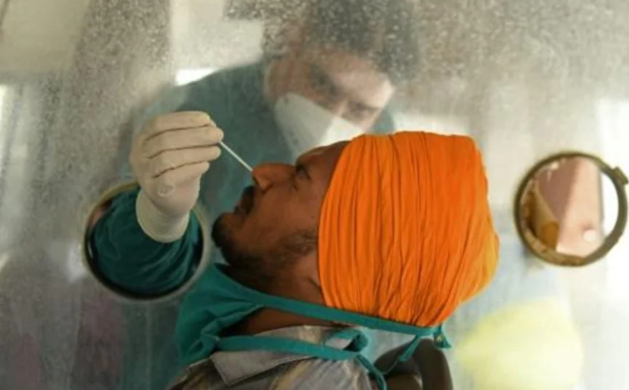 Un técnico sanitario toma una muestra de mucosa nasal a un hombre para hacer una prueba de detección del coronavirus, el 24 de mayo de 2021 en Amritsar, al norte de la India