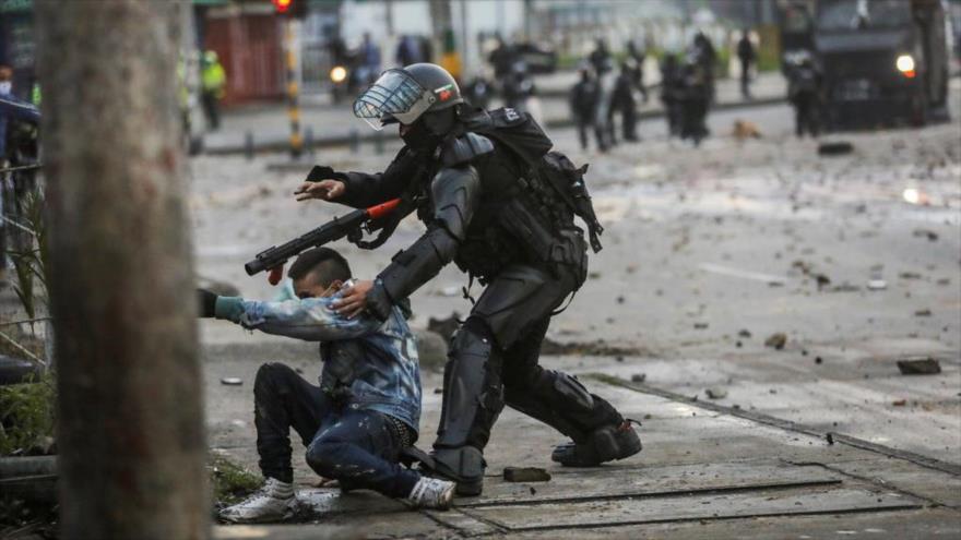 Un policía colombiano agarra a un hombre durante una protesta contra la reforma tributaria del Gobierno en Bogotá