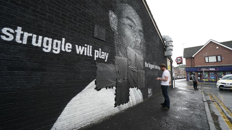 Un ciudadano inglés tapa los insultos racistas escritos sobre un mural de Marcus Rashford en Withington