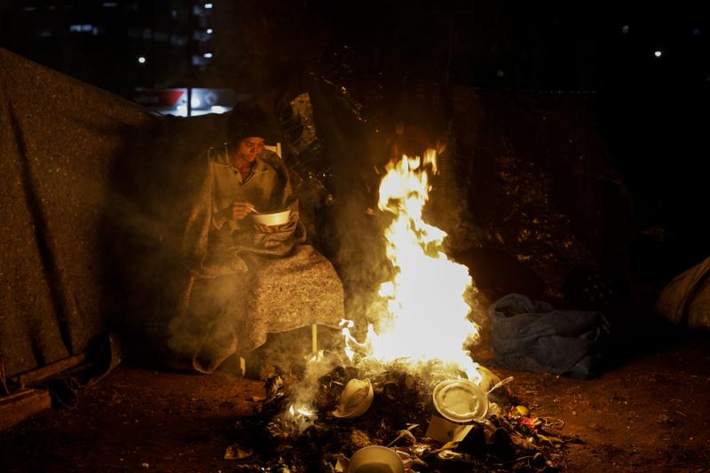 Indigente se protege del frío junto a una figata en Sao Paulo, Brasil, el jueves 29/7/2021