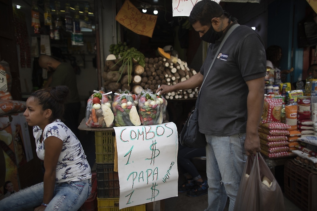 Un hombre mira verduras en un mercado de Caracas, Venezuela, el 11 de junio de 2021.