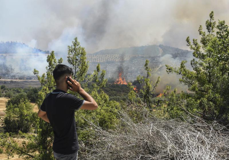 Un hombre mira los incendios forestales en un pueblo de Kacarlar cerca de la población costera mediterránea de Manavgat, Antalya, Turquía, el sábado 31 de julio de 2021