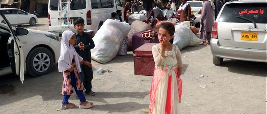 Tres menores afganos esperan en un puesto fronterizo pasar junto a su familia a la vecina Pakistán