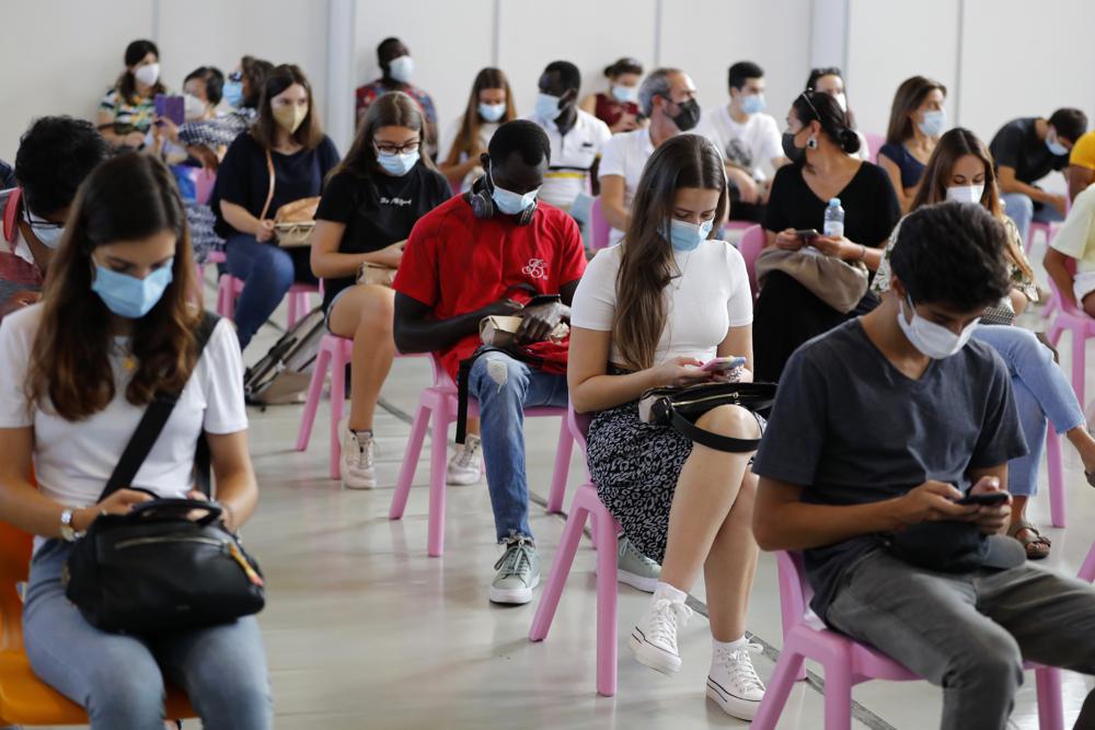 Jóvenes esperando en una sala tras recibir la vacuna del coronavirus en Lisboa, el sábado 11 de septiembre de 2021