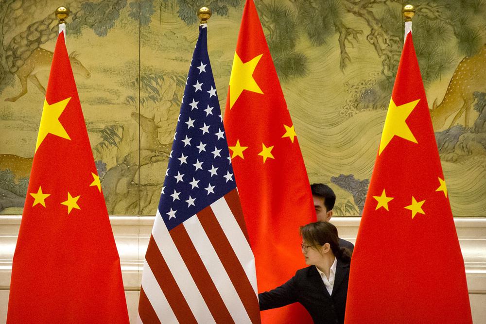 Banderas de EEUU y China en el lugar de negociaciones comerciales entre los dos países, en Beijing
