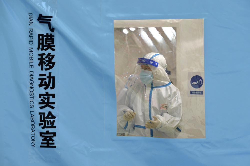 Persona, con traje de protección, trabaja en un laboratorio temporal para pruebas de detección del COVID-19, en la municipalía de Tianjin, en el norte de China, el 11/1/2022