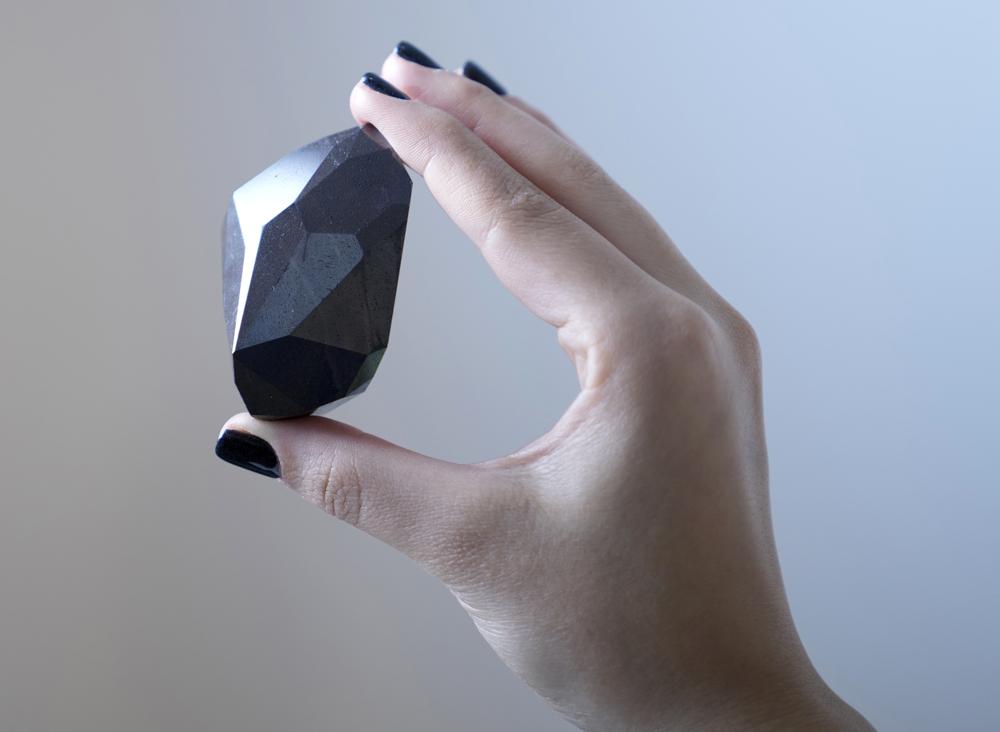 Empleada de Sothebys de Dubái muestra el diamante negro de 555,55 quilates llamado "El Enigma" que será subastado en la galería de Sothebys, en Dubái, Emiratos Árabes Unidos, el lunes 17 de enero de 2022
