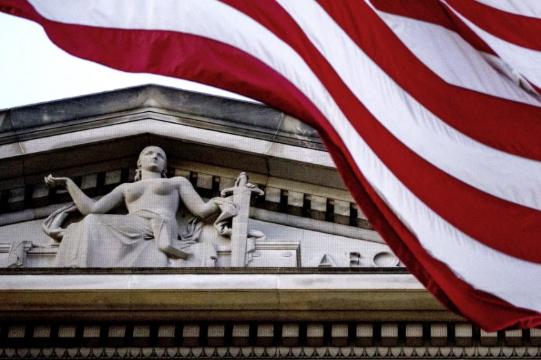 Una bandera estadounidense ondea frente al Departamento de Justicia en Washington, D.C.