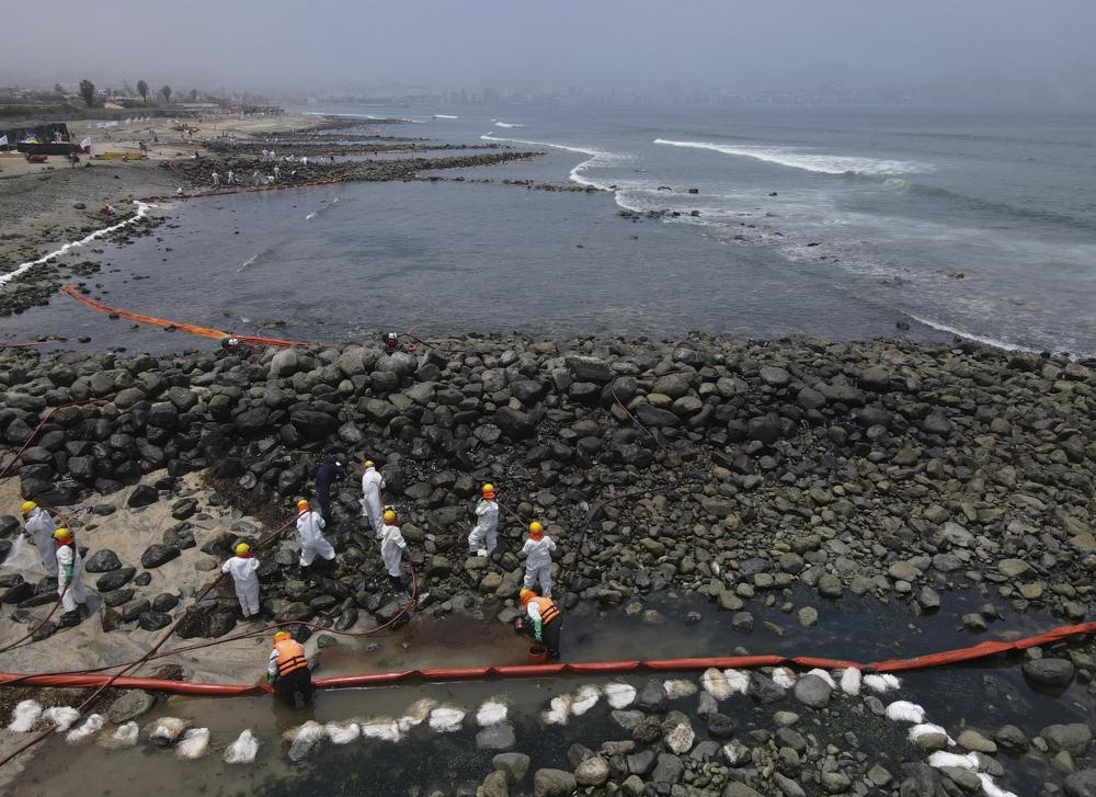 Trabajadores continúan en una campaña de limpieza después de un derrame de petróleo en la playa Pocitos en Ancón, Perú, el 15/2/2022