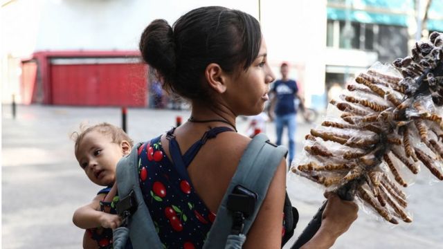 Mujer con bebé vendiendo en la calle, Caracas