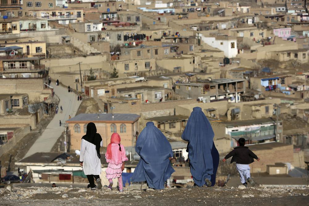 Mujeres con burkas caminan en la colina Nadir Khan con vista a Kabul, Afganistán