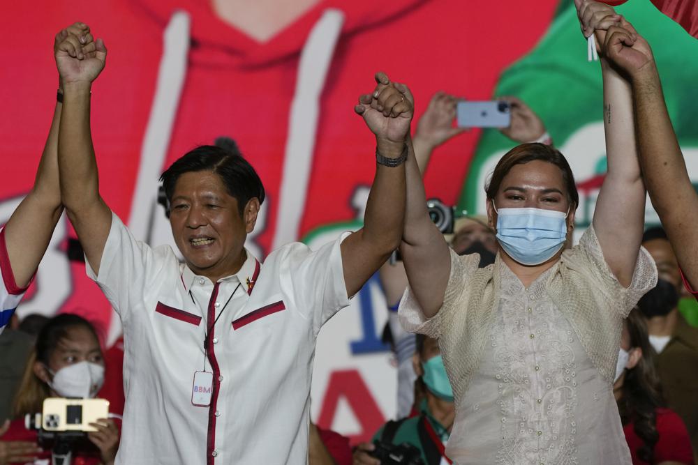 El candidato presidencial Ferdinand Marcos Jr., hijo del difunto dictador homónimo levanta los brazos junto con su compañera de fórmula Sara Duterte, hija del presidente de Filipinasactua
