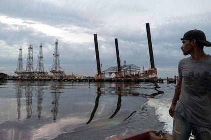 Un pescador navega junto a parte de la infraestructura en ruinas de una plataforma de la compañía petrolera estatal venezolana, PDVSA, en el lago Maracaibo en Cabimas, el 9 de mayo de 2019.
